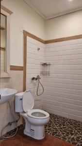 a bathroom with a white toilet and a sink at Phasouk Viengmai Villa in Luang Prabang