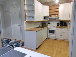 a small kitchen with white cabinets and a sink at Mesikämmen - Free parking & WiFi - Next to the forest - Rating 9,4 in Jyväskylä