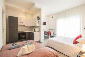 Il comprend une grande chambre avec deux lits et une cuisine. dans l'établissement Exclusive: Fronte Mare con Terrazzo e Parcheggio, à Rimini