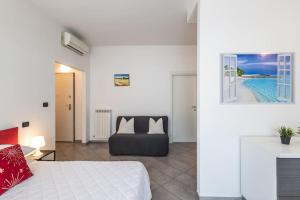 - une chambre avec un lit et un canapé dans l'établissement Exclusive: Fronte Mare con Terrazzo e Parcheggio, à Rimini