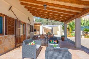 an outdoor patio with chairs and tables and awning at Vista Sol in Ariany