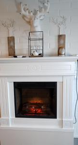 a fireplace with a white mantle with a fire place at Kuukkeli Saariselkä Inn in Saariselka