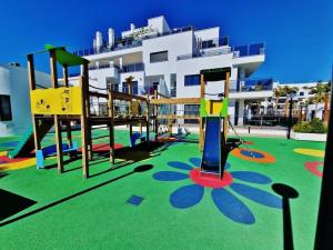 un parque infantil frente a un gran edificio en PUSHE Playa Granada Beach & Golf 28, en Motril