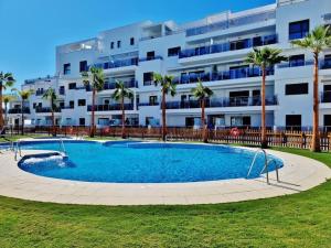 una piscina frente a un gran edificio de apartamentos en PUSHE Playa Granada Beach & Golf 28, en Motril