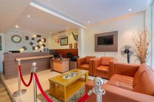 a living room with orange furniture and a red ribbon at Prime Palace Hotel - MG Road in Cochin