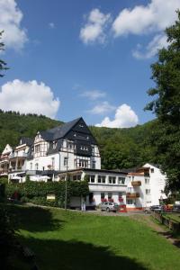 ein großes weißes Gebäude mit schwarzem Dach in der Unterkunft Bertricher Hof in Bad Bertrich