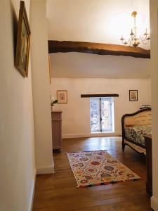 1 dormitorio con cama y alfombra en el suelo de madera en Maison Chinsa, en Saint-Angeau