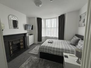 a bedroom with a bed and a fireplace and a mirror at Copperfield Homestay in Cardiff
