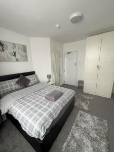 - une chambre avec un lit et une couverture tressée dans l'établissement Copperfield Homestay, à Cardiff