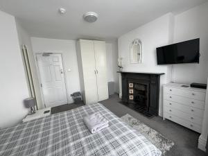 a bedroom with a bed and a tv and a fireplace at Copperfield Homestay in Cardiff