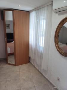 a room with a mirror and a door with a window at Apartment Bauk in Draga Bašćanska