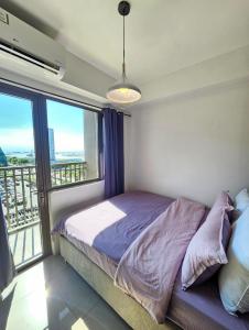 een slaapkamer met een bed en een groot raam bij k~crib at Shore Residences Tower A, MOA Complex in Manilla