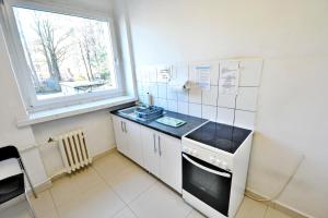 een kleine keuken met een fornuis en een raam bij Twój Hostel Klimczoka 7 in Katowice