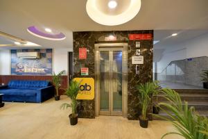 a lobby with a blue couch and a elevator at Belwood Inn Hotel Near Delhi Airport in New Delhi