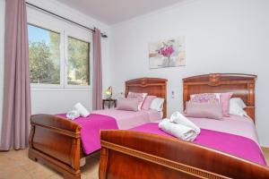 a bedroom with two beds with pink sheets at Vista Sol in Ariany +27 photos