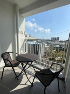 un balcón con 2 sillas y una mesa en el balcón en Hoya stay en Yeosu
