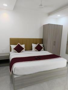 a bedroom with a large bed with a wooden headboard at GRACE REGENCY in Ernakulam