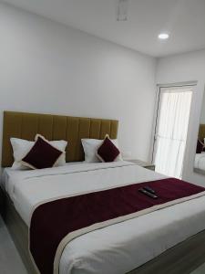 a bedroom with a large bed with pillows at GRACE REGENCY in Ernakulam