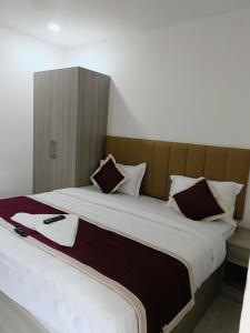 a bedroom with a large bed with a headboard at GRACE REGENCY in Ernakulam