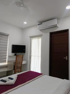 a bedroom with a bed and a television and a window at GRACE REGENCY in Ernakulam