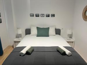 a bedroom with a large white bed with two tables at Céntrico apartamento a 200m de la playa y parking in Palamós