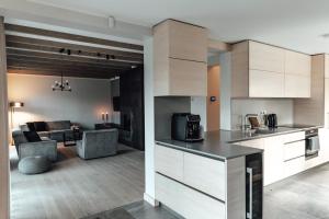 cocina y sala de estar con sofá y mesa en Jaunkapteiņi, en Dzeņi