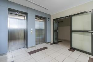 un pasillo vacío con ascensores en un edificio en Apartament Fregata, en Gdansk