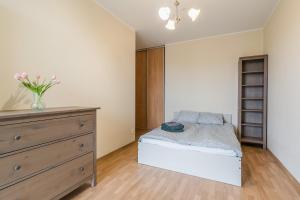 a bedroom with a bed and a dresser at Apartament Fregata in Gdańsk