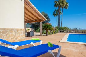 een villa met een zwembad en 2 ligstoelen bij Vista Sol in Ariany