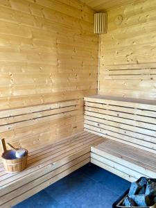 a wooden sauna with a bowl and a bucket at Resto domki letniskowe in Sarbinowo