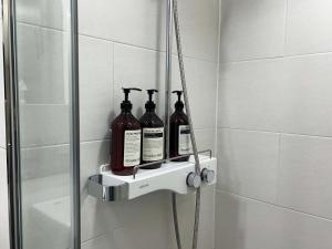 un estante de ducha con botellas en el baño en Hoya stay en Yeosu