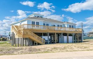 a large white house with a wooden deck at Swink Cottage in Southern Shores