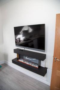 Elle comprend une télévision à écran plat installée sur un mur. dans l'établissement Unit 3 Modern Self Contained Apartment, à Cobh
