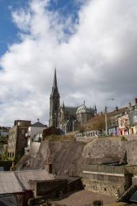 a church with a steeple in a city with buildings at Unit 3 Modern Self Contained Apartment in Cobh