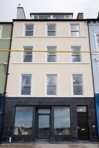 - un grand bâtiment blanc avec des fenêtres dans l'établissement Unit 3 Modern Self Contained Apartment, à Cobh