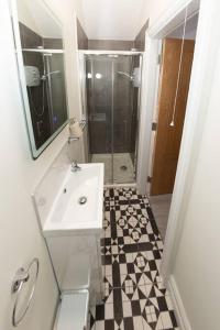 a white bathroom with a sink and a shower at Unit 3 Modern Self Contained Apartment in Cobh