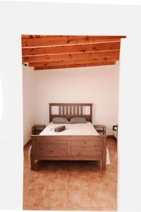 埃爾梅達諾的住宿－Integral Coliving Surf Yoga House，一间卧室设有一张木床和木制天花板