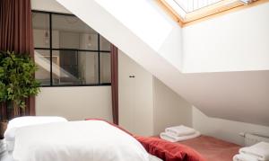 an attic bedroom with a bed and stairs at Apartament SUNSET SurfingBird Dźwirzyno in Dźwirzyno