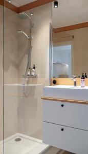 a bathroom with a shower and a white sink at Apartament SUNSET SurfingBird Dźwirzyno in Dźwirzyno