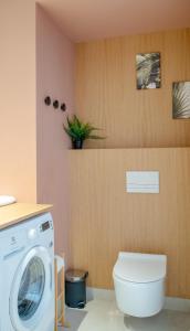uma casa de banho com uma máquina de lavar roupa e um WC em Apartament SUNSET SurfingBird Dźwirzyno em Dźwirzyno