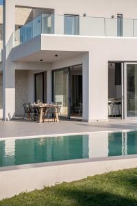 an external view of a house with a swimming pool at Villa Zefyros With Sea View in Plataniás