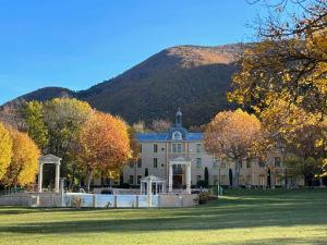 un gran edificio con una montaña en el fondo en le 24 du château en Montbrun-les-Bains