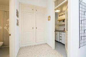 El Loft de la Reina - Apartamento Interior في خيريز دي لا فرونتيرا: مطبخ بدولاب ابيض وباب ابيض