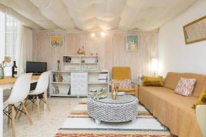 El Loft de la Reina - Apartamento Interior في خيريز دي لا فرونتيرا: غرفة معيشة مع أريكة وطاولة