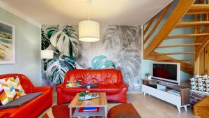 salon z czerwoną kanapą i telewizorem w obiekcie Ferienhaus Fischerhaus w mieście Seedorf