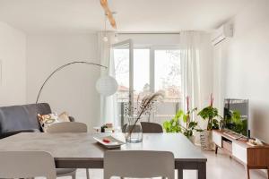 a white living room with a table and chairs at casa MEV è un attico in centro a Fiume Veneto in Fiume Veneto