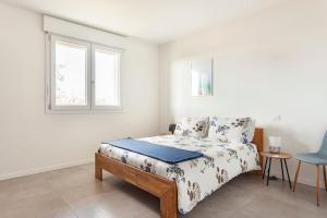 里耶卡威尼托的住宿－casa MEV è un attico in centro a Fiume Veneto，一间卧室设有一张床和两个窗户。