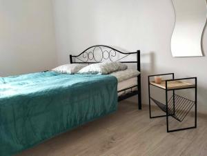 1 dormitorio con 1 cama y mesa auxiliar en Apartament Alma en Srebrna Góra