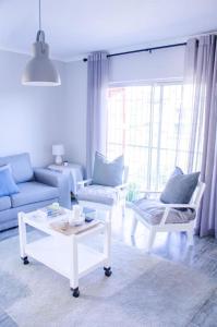 ein Wohnzimmer mit einem Sofa und einem Tisch in der Unterkunft Neat & New Private 2 bedroom Backyard Flat. in Windhoek