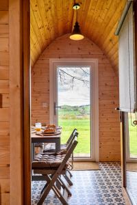 um quarto com uma mesa e cadeiras numa casa de madeira em Finest Retreats - The Pods em Camerton